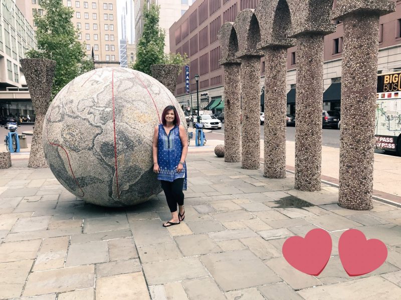 listening to patients | Scleroderma News | Amy Gietzen attends the National Scleroderma Conference in Philadelphia in 2018. In the photo she's posing outside next to a large stone globe.